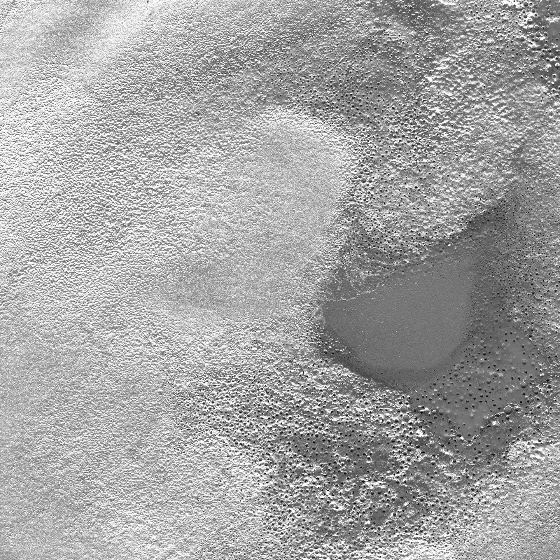 Rough Gray Plaster Texture With Worn Patches PNG. This PNG texture shows a gray plaster surface with dense pitting