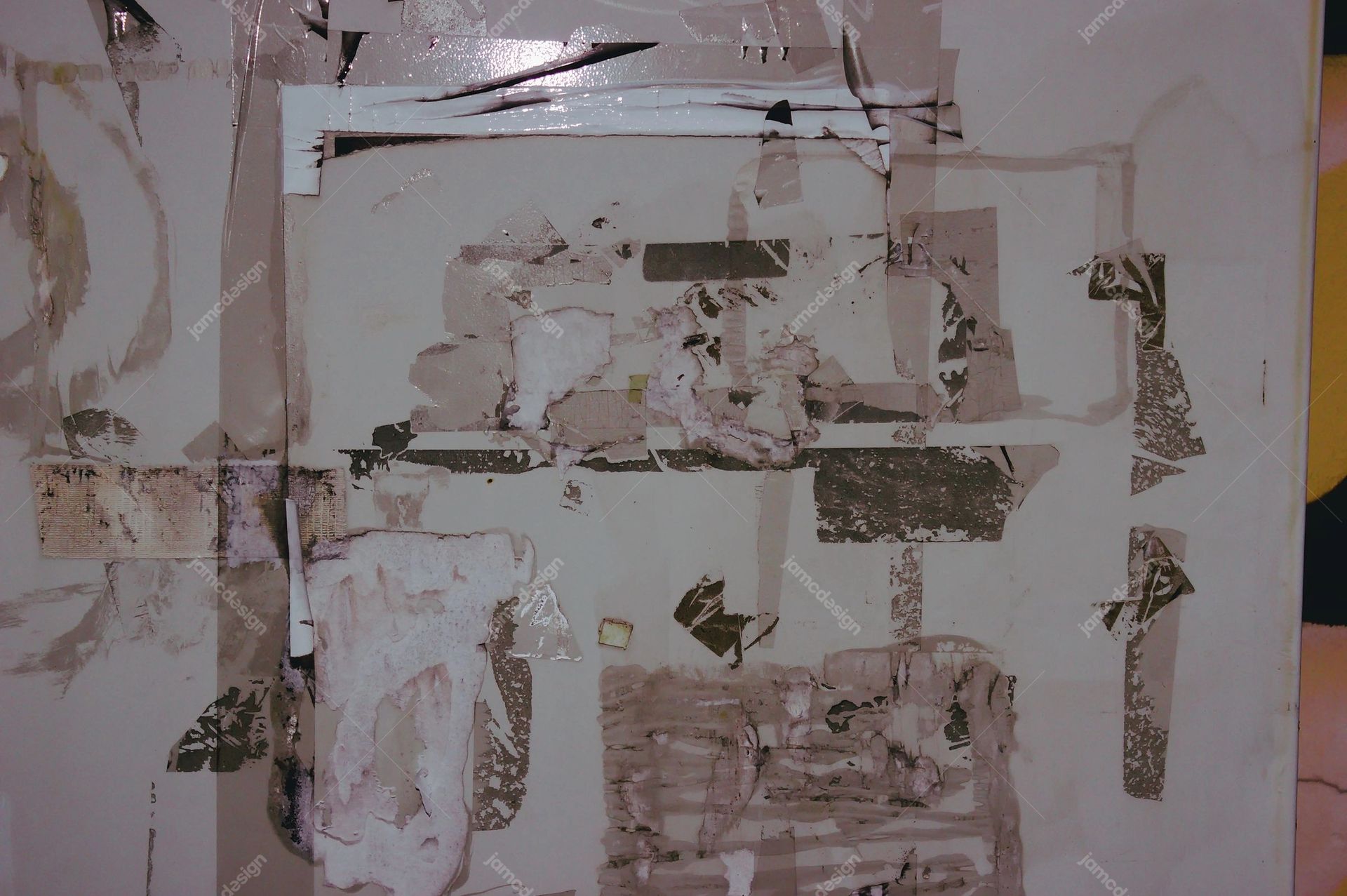 Gray Wall Texture With Torn Poster Layers. This JPG texture shows a gray wall covered in torn, overlapping poster remnants, with a distressed