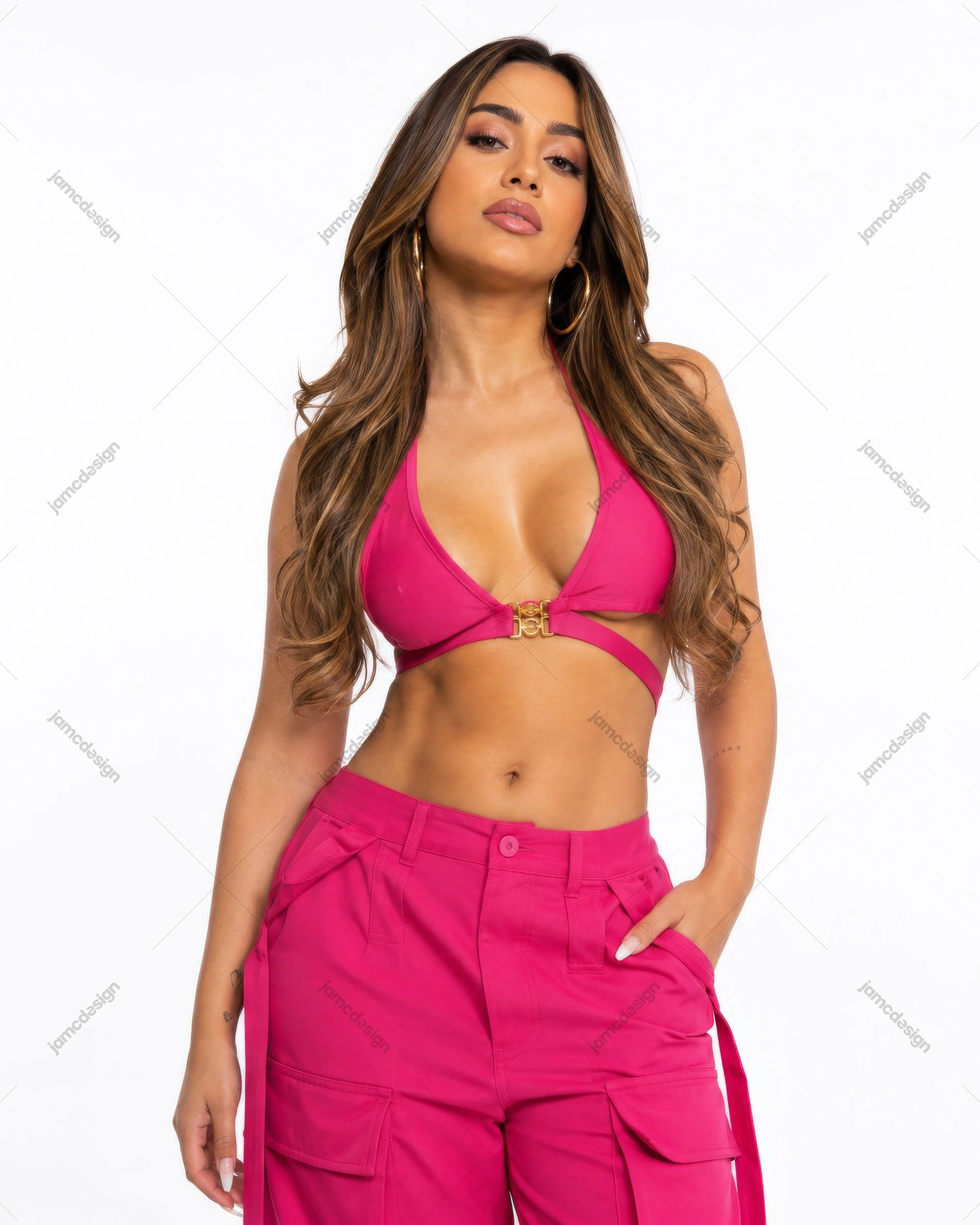 Foto De Mulher Com Top Halter Rosa E Calças Cargo. Foto de moda em estúdio de uma mulher usando um top halter rosa brilhante com fecho dourado e calças cargo