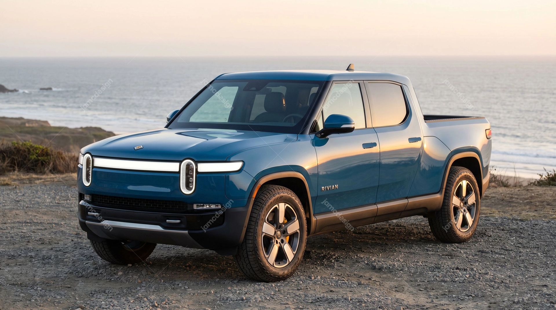 Blue Rivian R1T Pickup At Coastal Sunset. A JPG photo captures a blue pickup truck parked on a rocky shore beside the ocean at sunset
