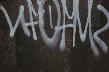 Dark Concrete Wall Texture With Pale Graffiti