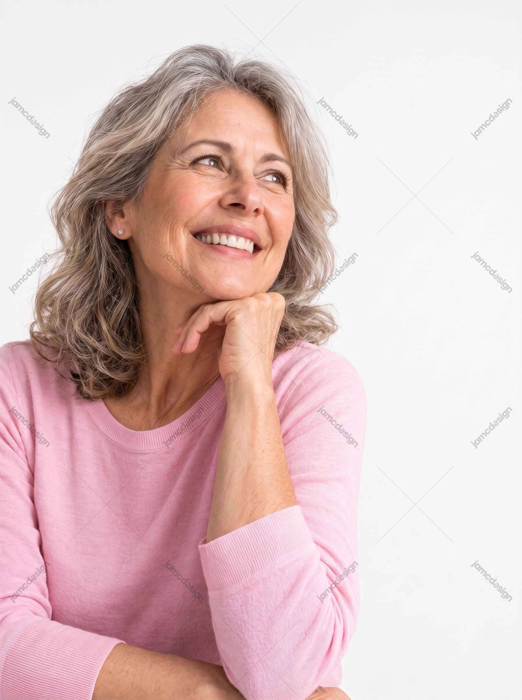 Close-Up Photo Of A Smiling Mature Woman. This photorealistic JPG photo shows a smiling mature woman resting her chin on her hand against a bright
