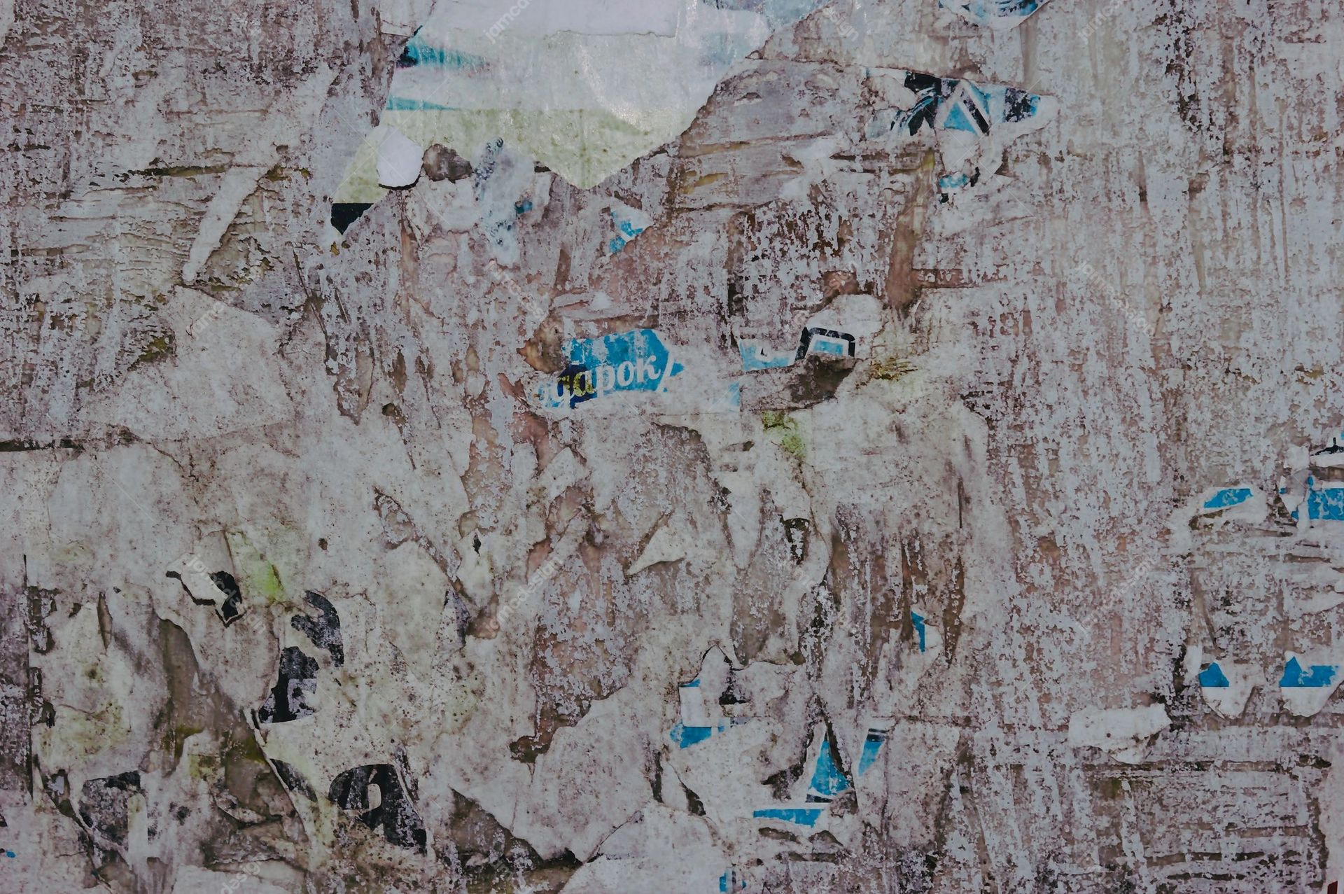 Grunge Texture Of Torn Layered Posters On A Wall. This JPG texture shows overlapping, torn paper posters on a weathered wall