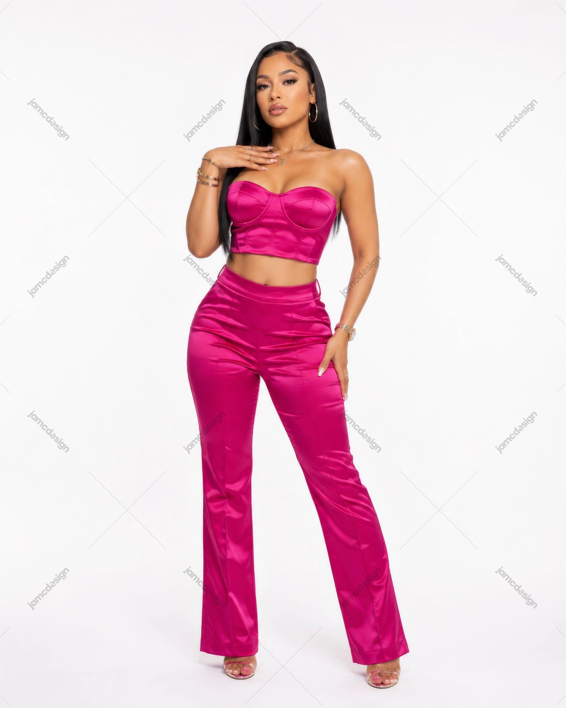 Foto De Mulher Com Top Corset E Calças Em Cetim Rosa. Fotografia de moda em estúdio de uma mulher usando um conjunto de duas peças em cetim rosa brilhante