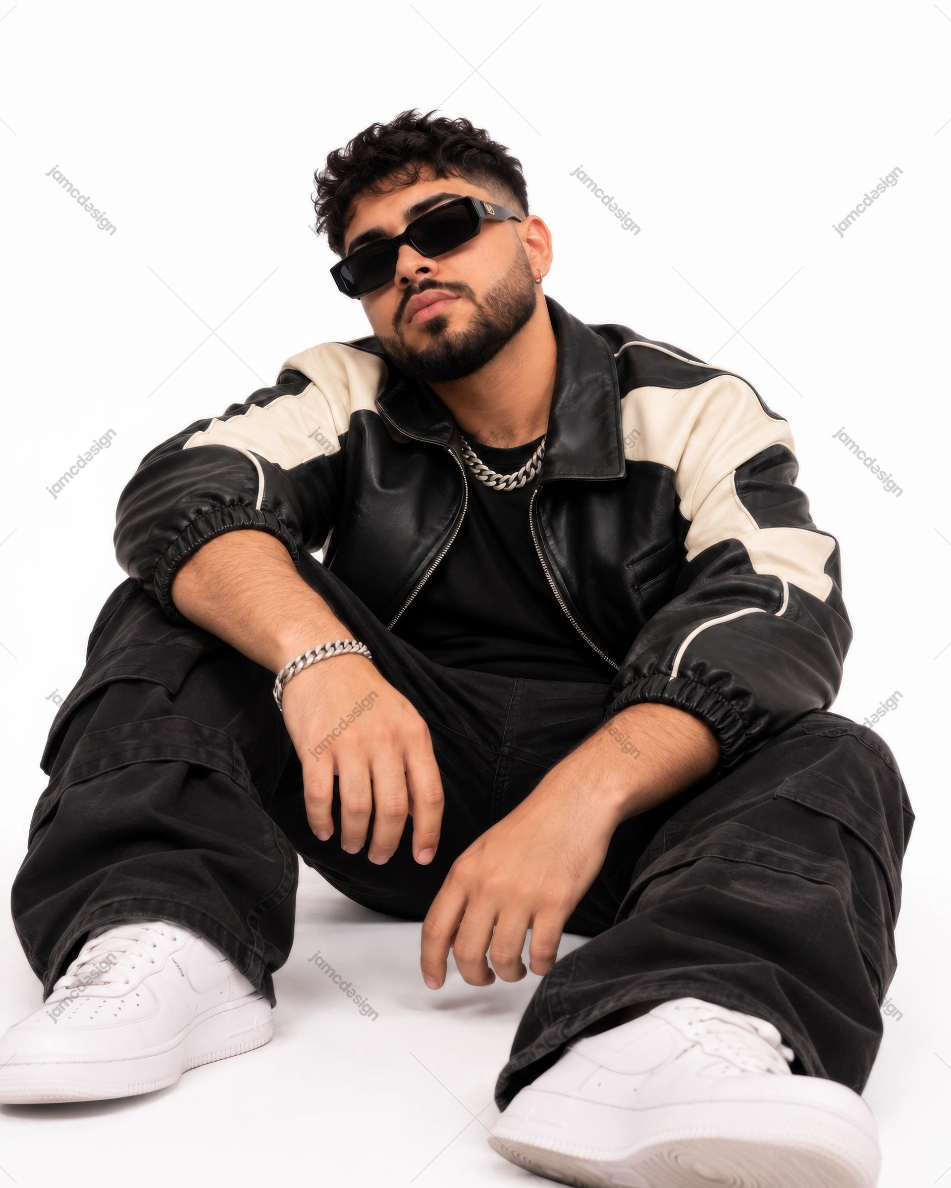 Seated Man In Two Tone Leather Jacket And Sunglasses. Download this PNG photo of a seated man wearing a black leather jacket with cream panels