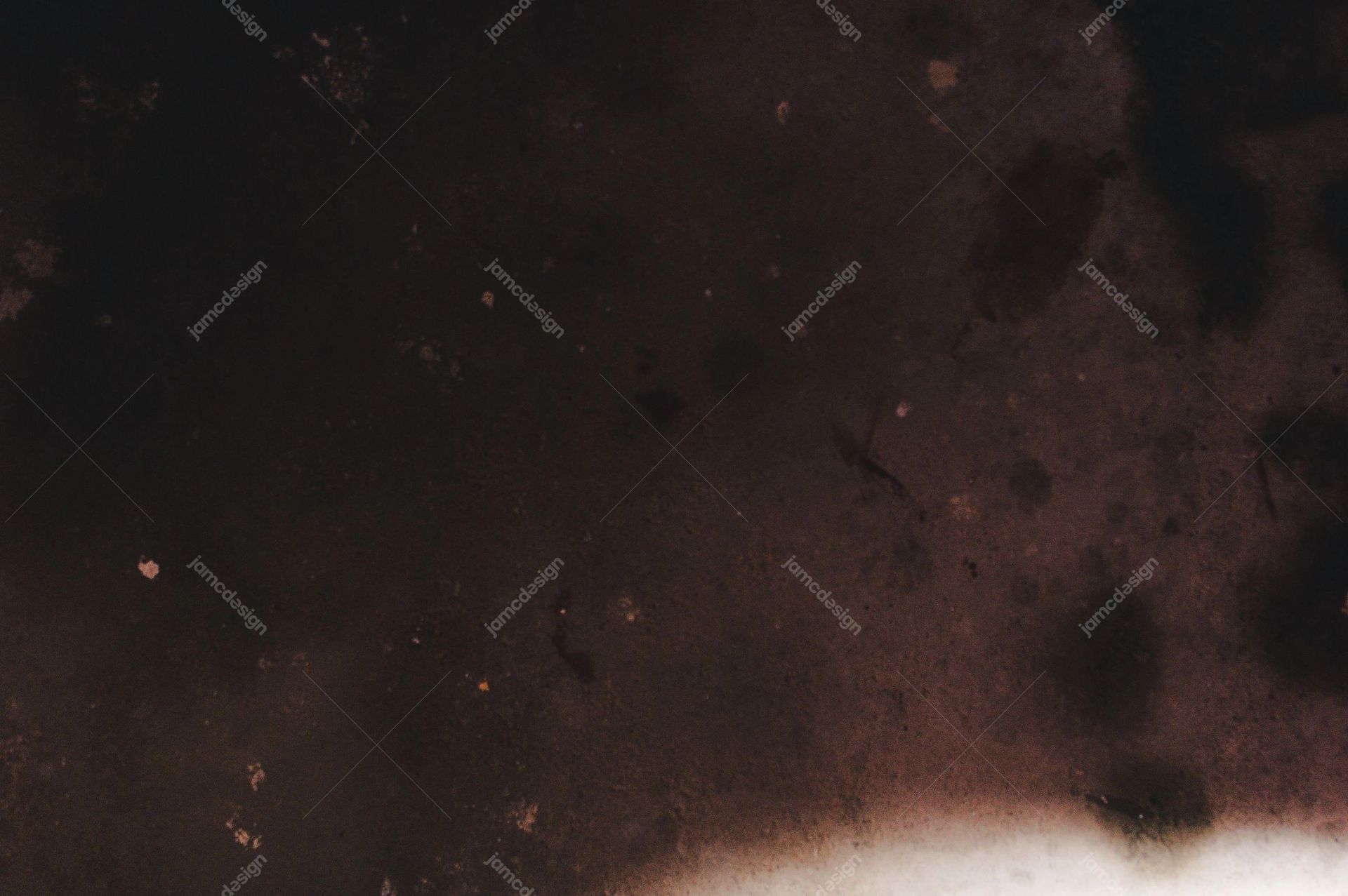 Dark Film Texture With Lower Edge Light Leak. This JPG texture has a dark black and brown surface, scattered glowing speckles