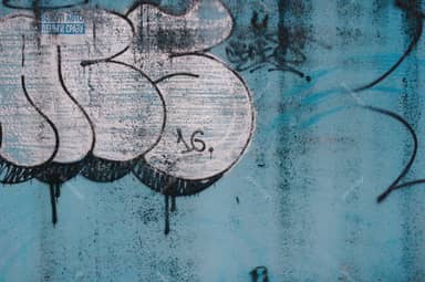 Weathered Turquoise Wall Texture With Oversized Graffiti
