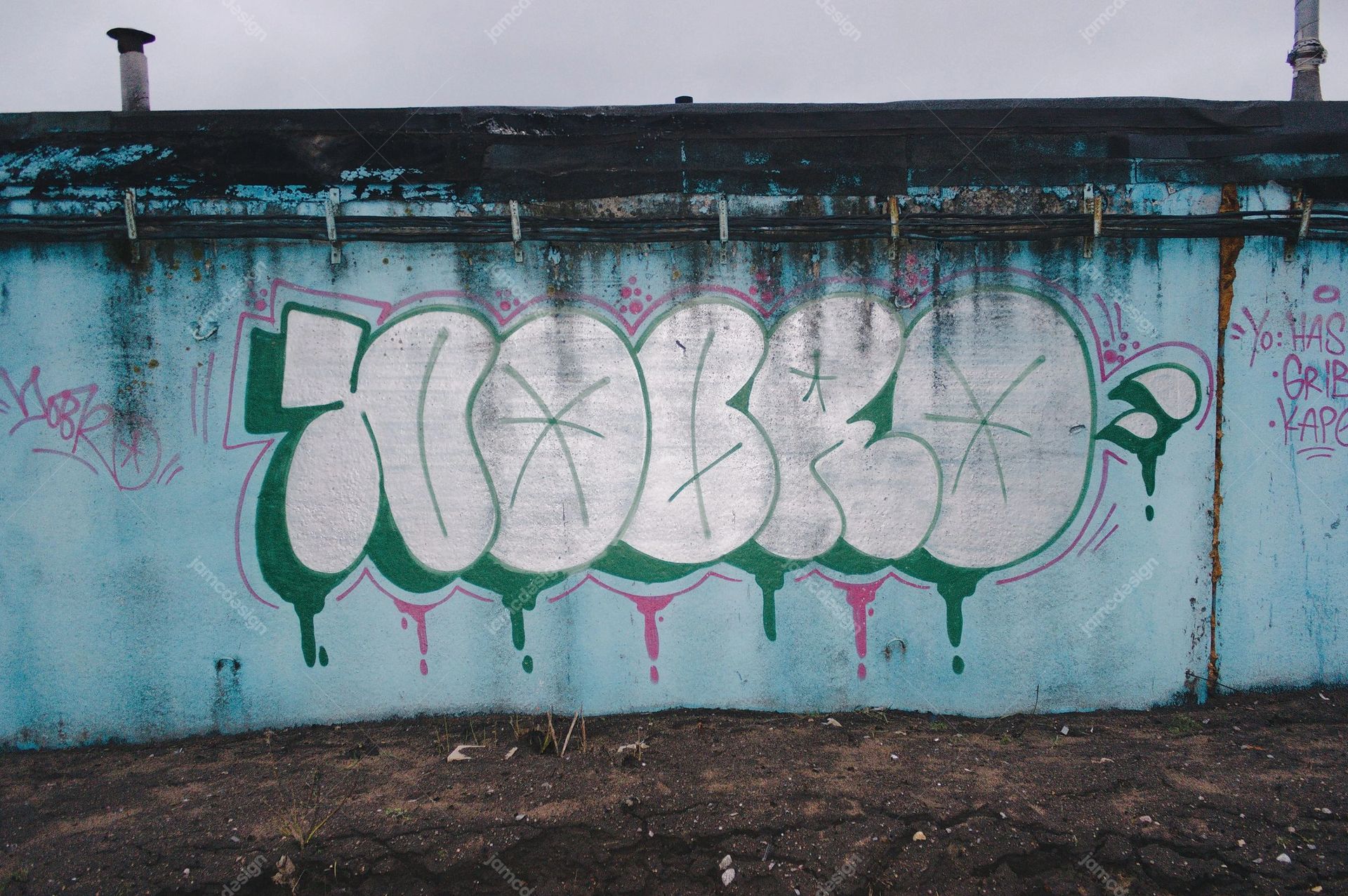 Teal Wall Texture With Silver Graffiti. Download this JPG texture showing a weathered urban wall covered in large silver graffiti lettering
