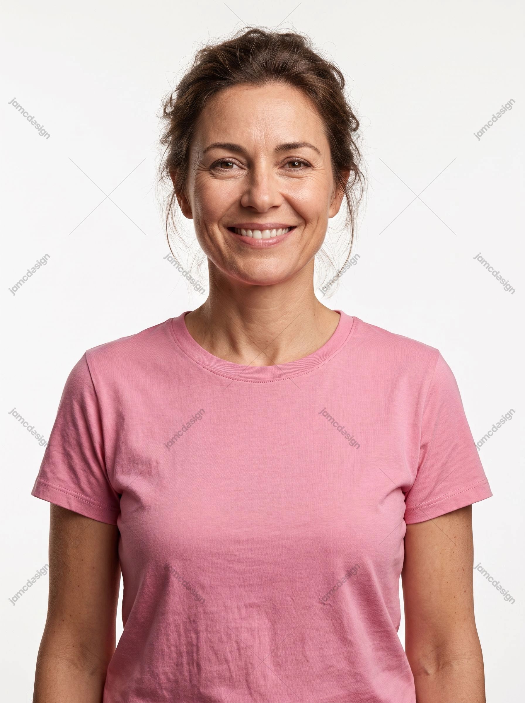 Smiling Brunette Woman In A Pink T-Shirt. This JPG photo shows a smiling brunette woman in a pink T-shirt against a plain light background, in a bright