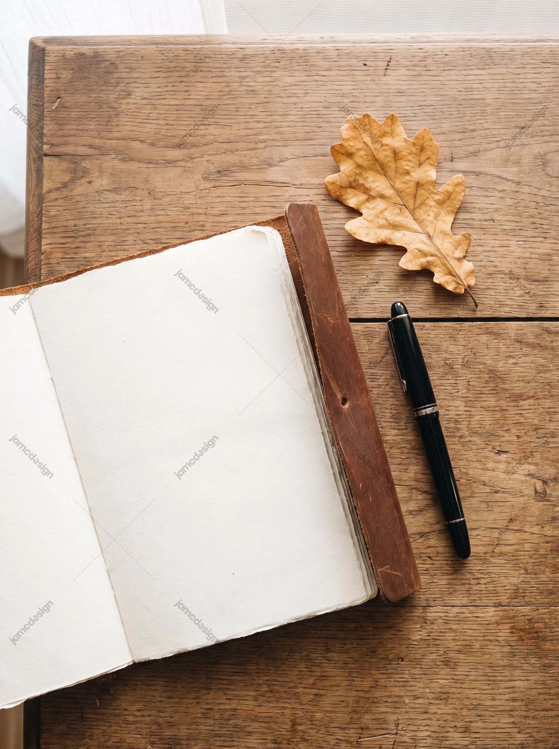 Carnet Ouvert Avec Stylo Noir Et Feuille De Chêne. Cette photo JPG montre un journal ouvert, un stylo noir et une feuille de chêne séchée sur un bureau