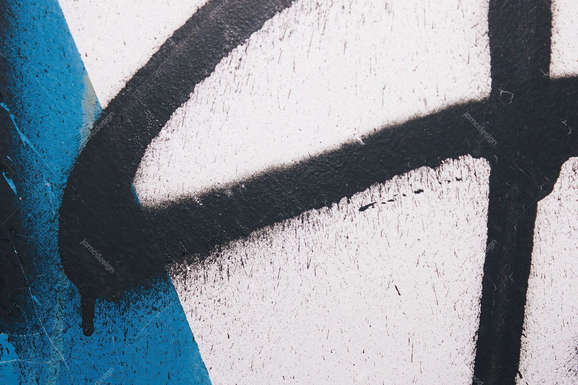 White Wall Texture With Black Graffiti And Blue Paint. This JPG texture captures a rough white wall marked with bold black graffiti and vivid blue paint