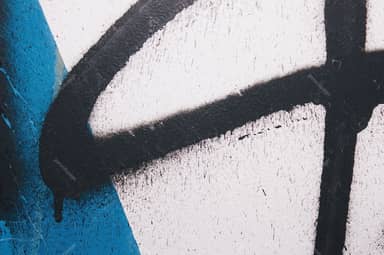 White Wall Texture With Black Graffiti And Blue Paint