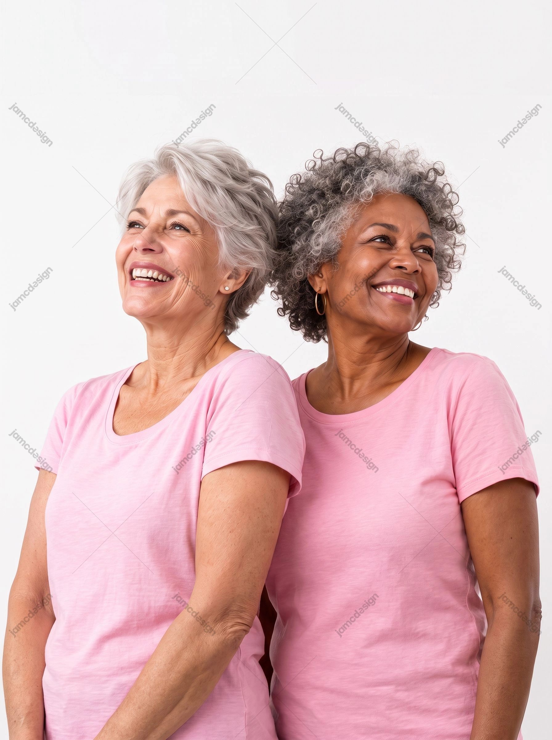 Smiling Older Women In Pink Against A White Background. This JPG photo shows two older women smiling side by side in pink shirts against a plain white