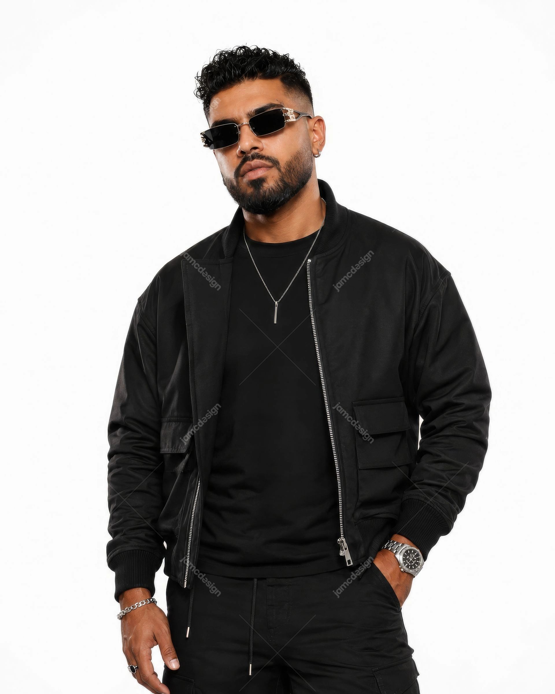 Fashionable Man In Black Streetwear And Sunglasses Photo. Studio photo of a male model in an all-black streetwear outfit, featuring a zippered bomber jacket
