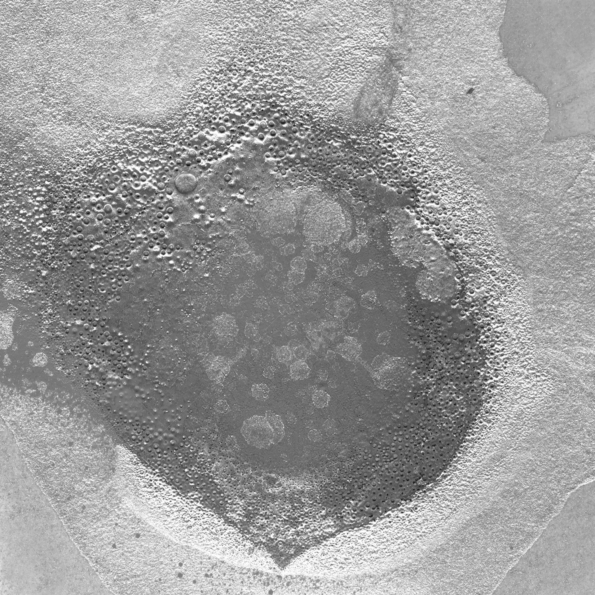 Concrete Texture With A Broad Pitted Circle PNG. This PNG concrete texture shows a broad round, pitted area in mottled gray