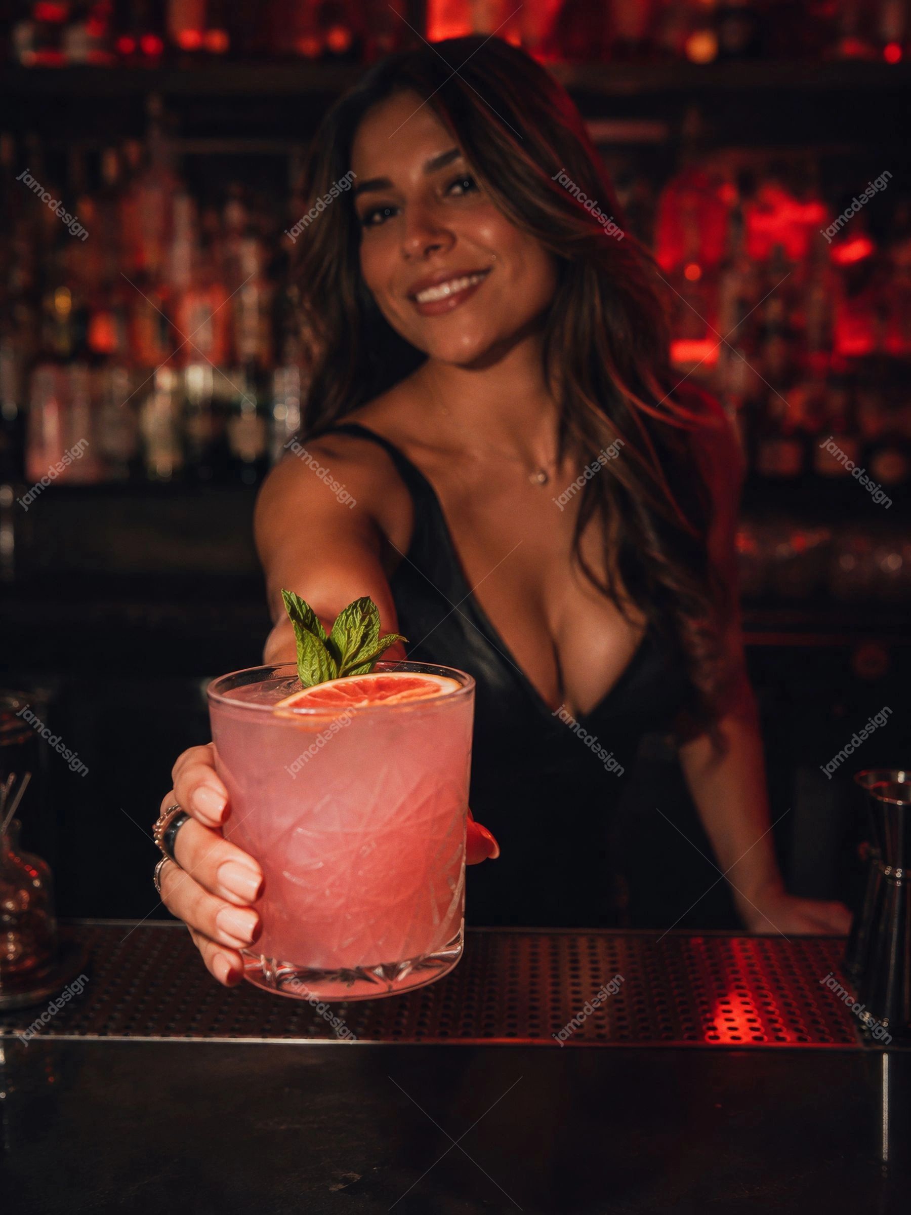 Bartender Com Coquetel Rosa Em Bar De Boate Com Luz Vermelha. Esta foto em JPG mostra uma bartender sorridente apresentando um coquetel rosa em um copo