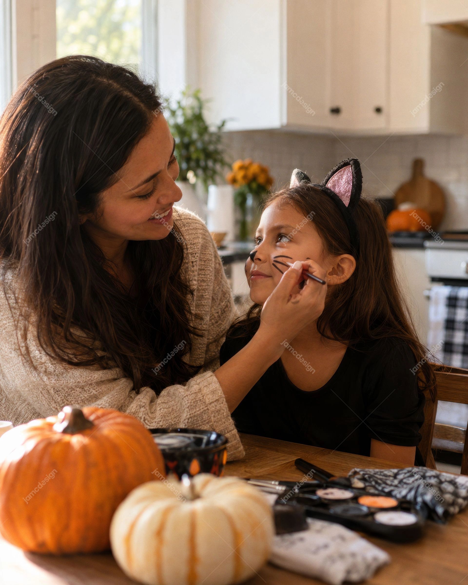 Madre Maquillando A Su Hija Como Gata Para Halloween. Esta foto realista en JPG muestra a una madre maquillando a su hija como un gato en una cálida cocina