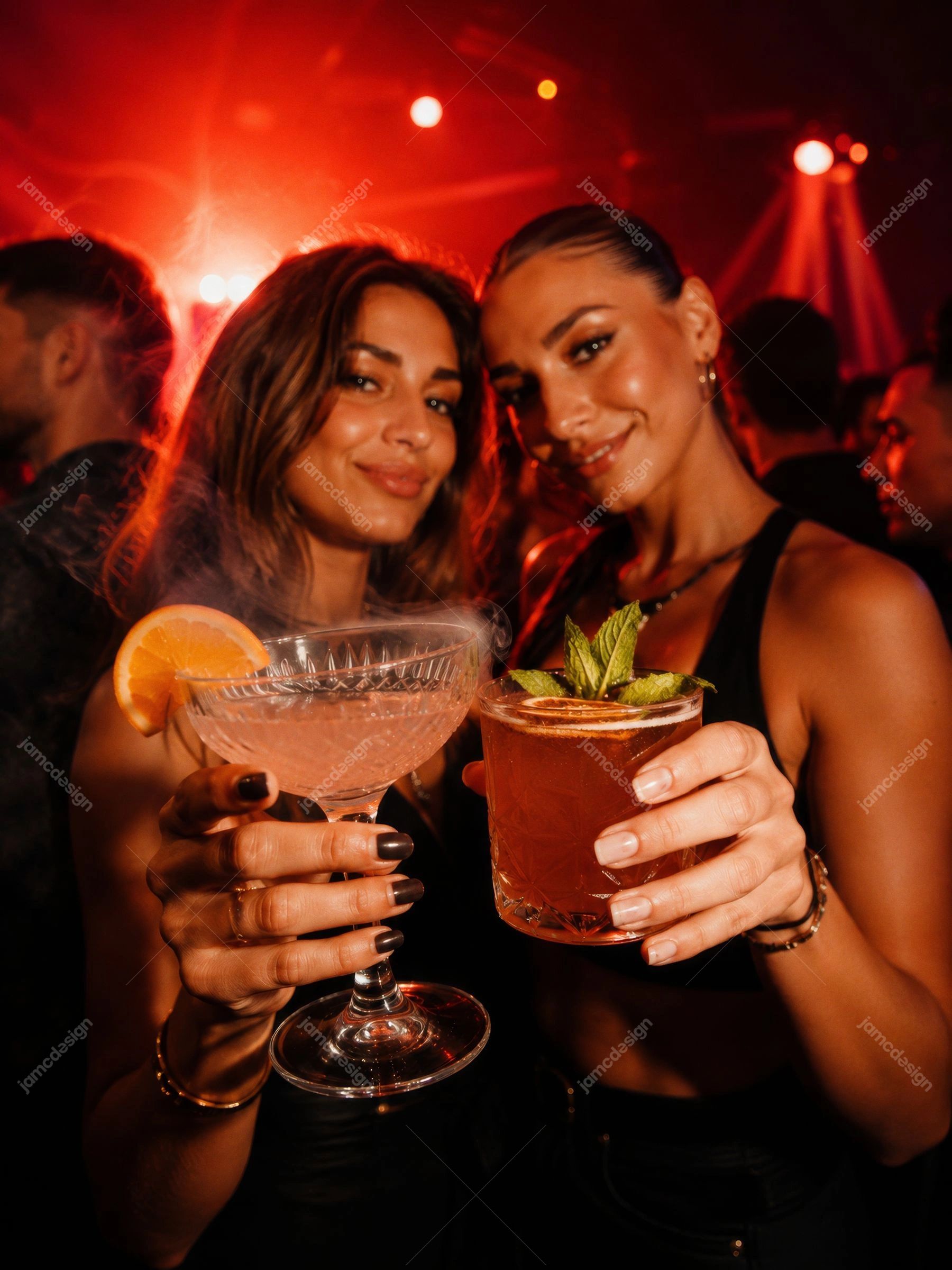 Retratos De Amigas Com Bebidas Vermelhas Em Boate. Foto em JPG de duas mulheres brindando com coquetéis em uma boate iluminada em vermelho